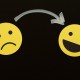 An arrow points from a sad yellow emoji face on the left to a happy yellow emoji face on the right against a black background.