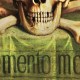 Illustration of a skull with crossed bones on a vibrant green background. The phrase "Memento mori!" is boldly inscribed beneath the skull.